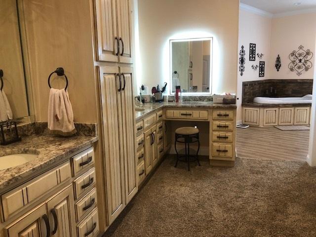 bathroom with ornamental molding, a bath, and oversized vanity