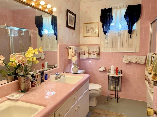 bathroom featuring backsplash, toilet, large vanity, and tile walls