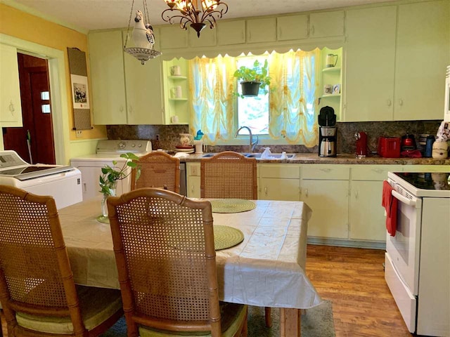 kitchen with a notable chandelier, light wood-type flooring, pendant lighting, white appliances, and washer and clothes dryer