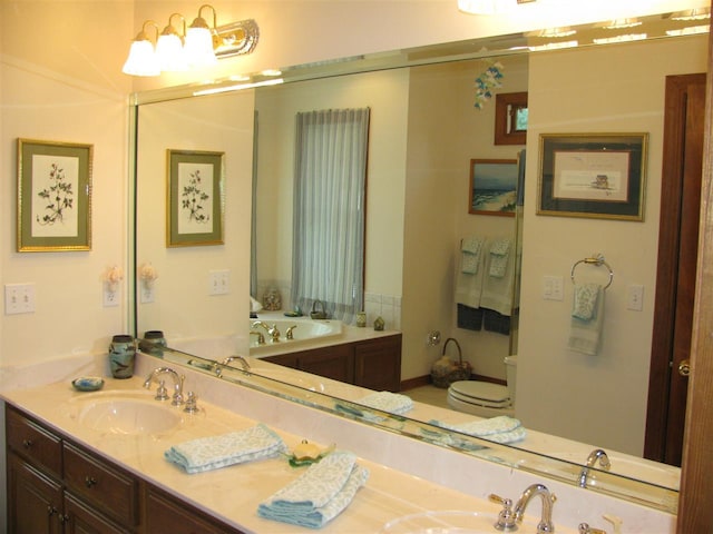 bathroom featuring toilet, a washtub, and vanity