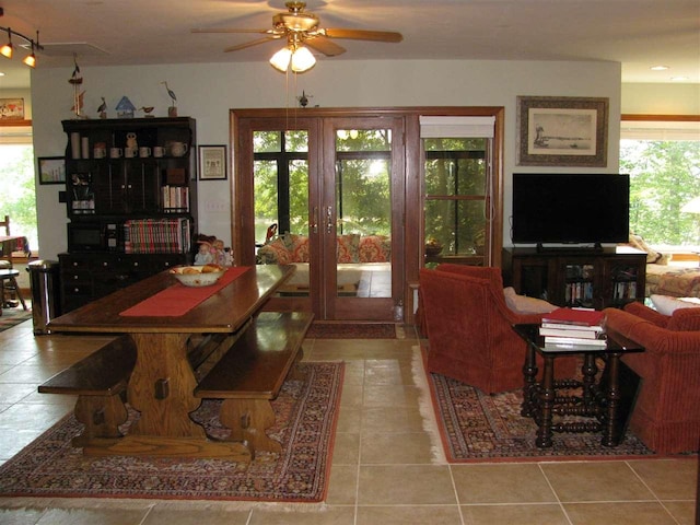 living room featuring light tile floors, plenty of natural light, rail lighting, and ceiling fan