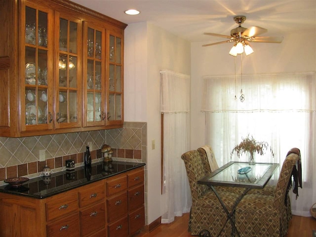 kitchen with backsplash, ceiling fan, and hardwood / wood-style flooring