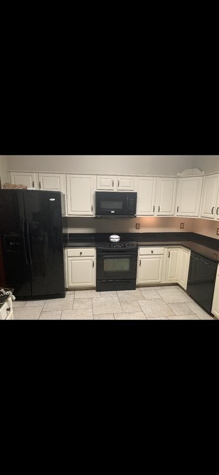 kitchen with light tile floors, white cabinetry, and black appliances