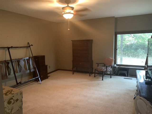 living area featuring light carpet and ceiling fan