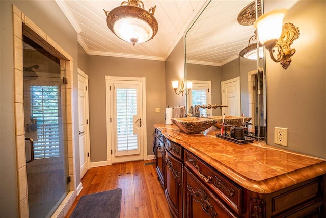 kitchen with dark hardwood / wood-style flooring, decorative light fixtures, sink, and crown molding