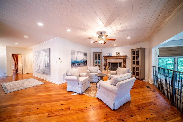 living room featuring crown molding, light hardwood / wood-style floors, and ceiling fan