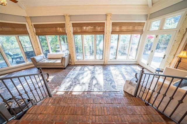 sunroom / solarium with lofted ceiling, ceiling fan, and a healthy amount of sunlight