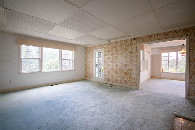 carpeted spare room featuring a paneled ceiling