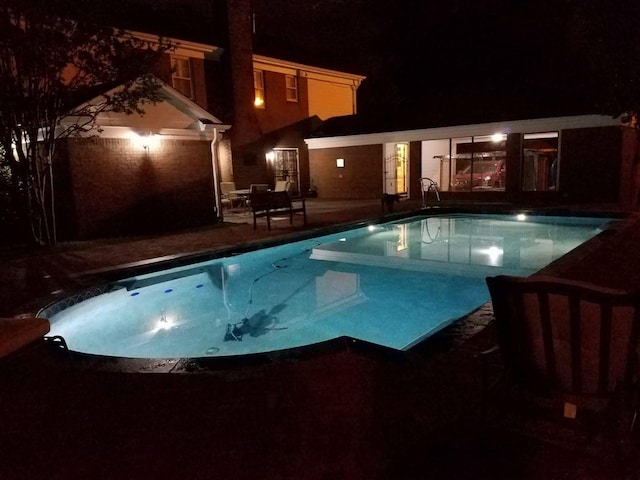 pool at twilight with a patio area