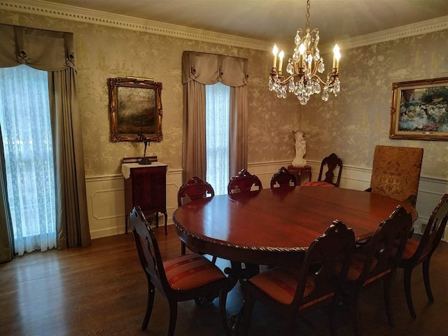 dining area featuring dark hardwood / wood-style flooring, crown molding, and a chandelier