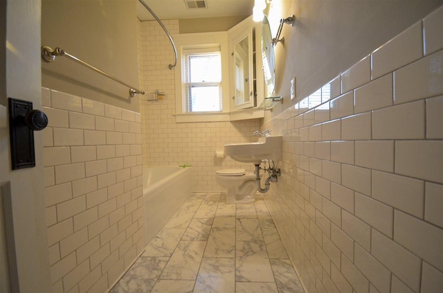 full bathroom with toilet, bathing tub / shower combination, tile walls, tile floors, and sink