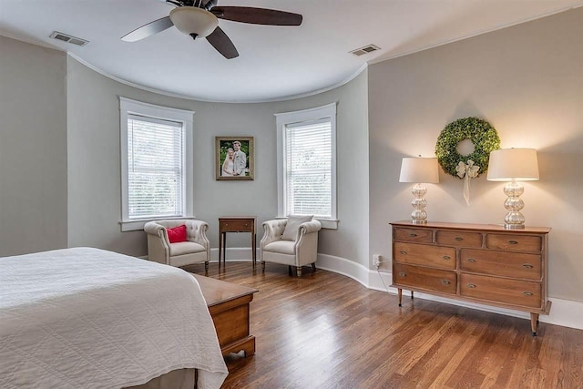 bedroom featuring dark hardwood / wood-style floors, ornamental molding, ceiling fan, and multiple windows