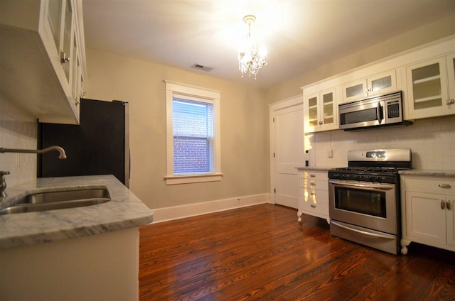 kitchen with stainless steel appliances, tasteful backsplash, dark wood-type flooring, and white cabinetry