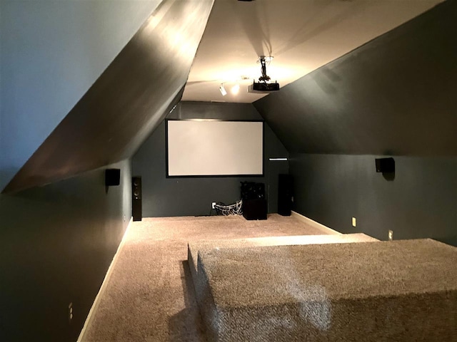 carpeted home theater room featuring lofted ceiling