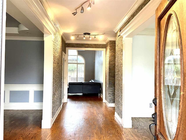 corridor featuring rail lighting, dark hardwood / wood-style floors, and ornamental molding