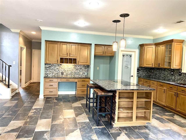 kitchen featuring hanging light fixtures, tasteful backsplash, a kitchen island, a kitchen bar, and dark tile flooring