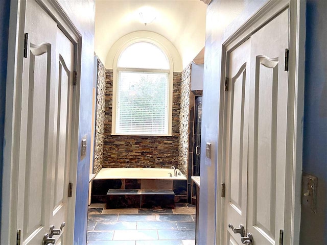 bathroom featuring a bath to relax in and tile floors