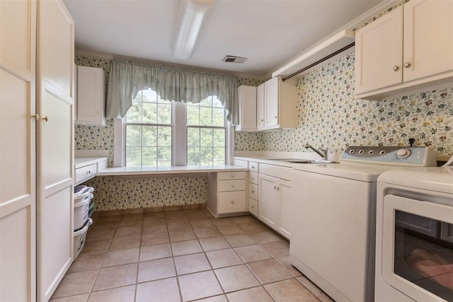 laundry room with light tile floors, cabinets, separate washer and dryer, and sink