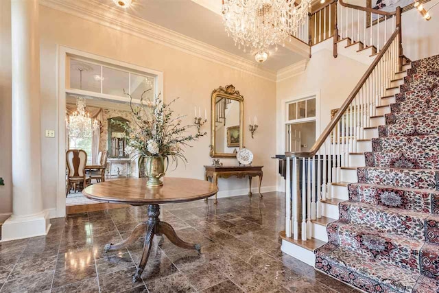 tiled foyer entrance featuring a high ceiling, a chandelier, and crown molding