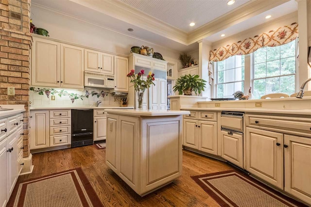 kitchen with dark hardwood / wood-style flooring, backsplash, brick wall, and a center island