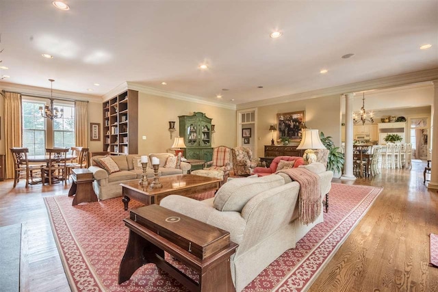 living room featuring light hardwood / wood-style floors, ornamental molding, and a chandelier