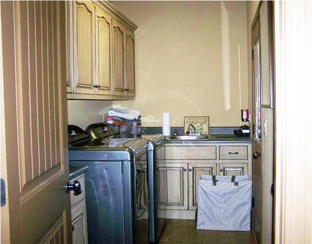 laundry room featuring cabinets, independent washer and dryer, and sink