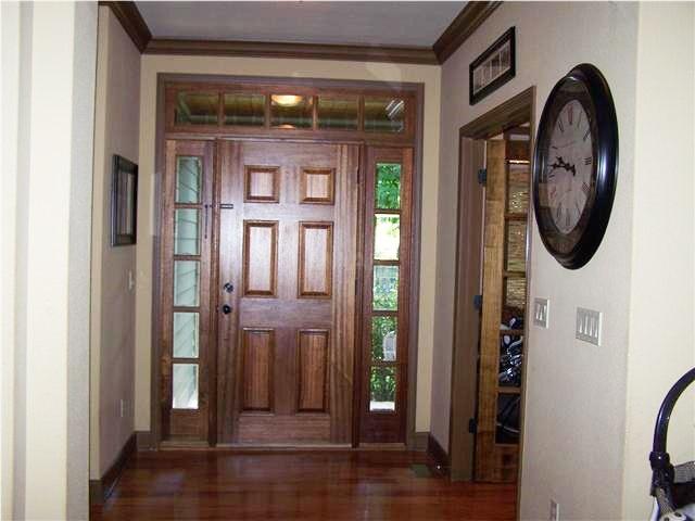 foyer with ornamental molding and dark wood-type flooring