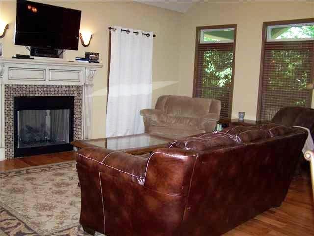 living room featuring hardwood / wood-style floors and a tiled fireplace