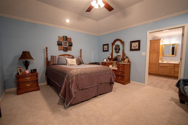 bedroom with light carpet, a tray ceiling, ceiling fan, and ensuite bathroom