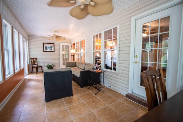 sunroom / solarium featuring a healthy amount of sunlight and ceiling fan