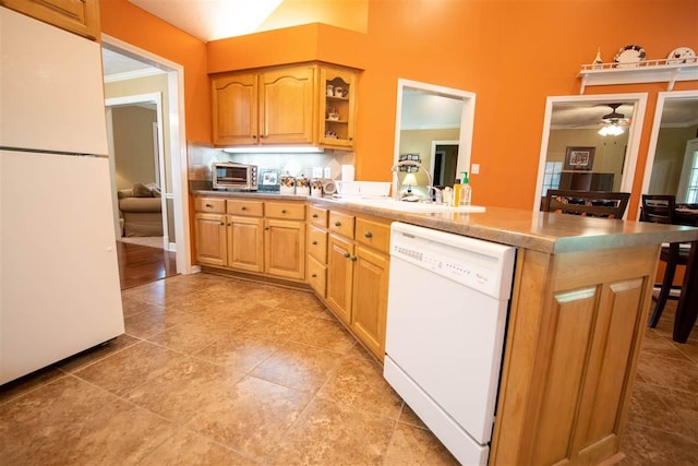 kitchen with light tile flooring, tasteful backsplash, ceiling fan, a breakfast bar, and white appliances