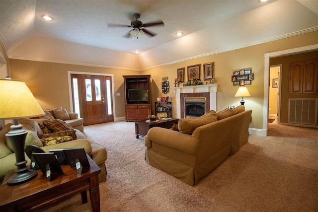 living room with a raised ceiling, ceiling fan, a fireplace, and light colored carpet