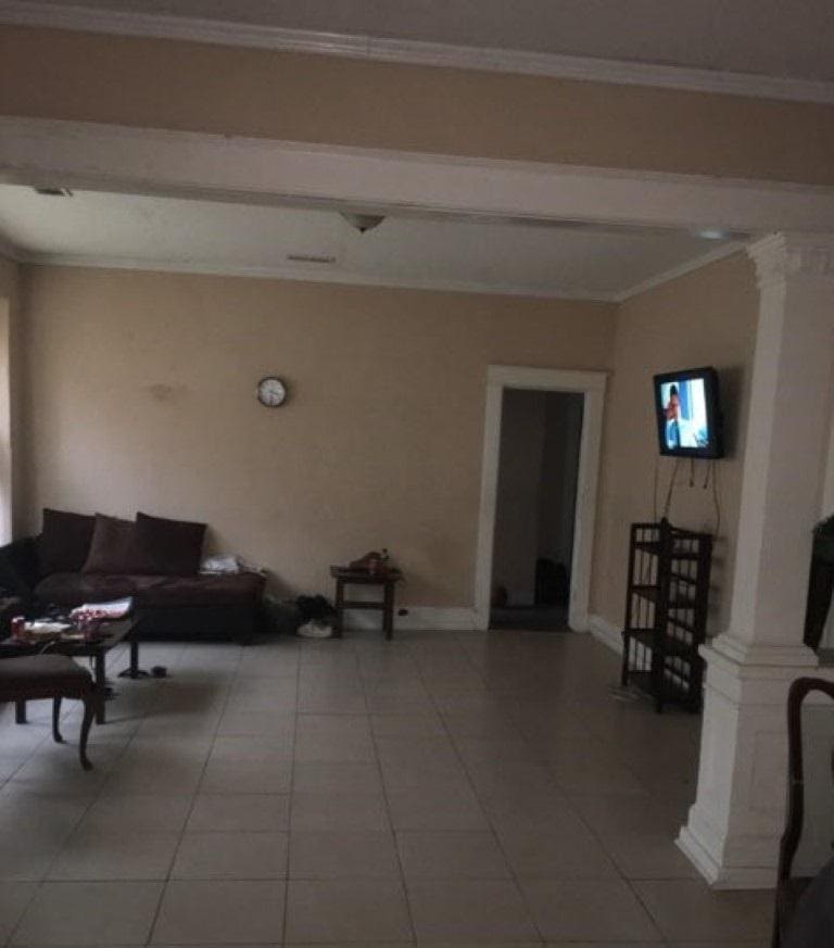 tiled living room featuring decorative columns and crown molding