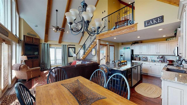 dining room featuring beam ceiling, dark wood-type flooring, high vaulted ceiling, and ceiling fan with notable chandelier