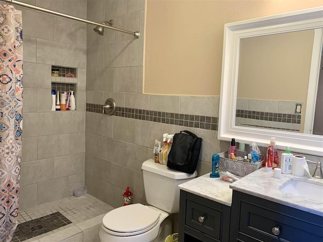 bathroom with vanity, tile walls, toilet, and walk in shower