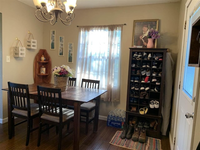 dining area with dark hardwood / wood-style floors and an inviting chandelier