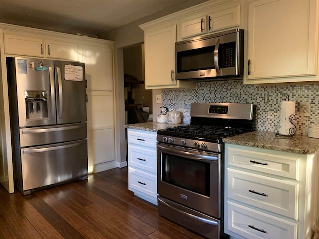 kitchen featuring dark hardwood / wood-style flooring, stainless steel appliances, stone counters, and white cabinets