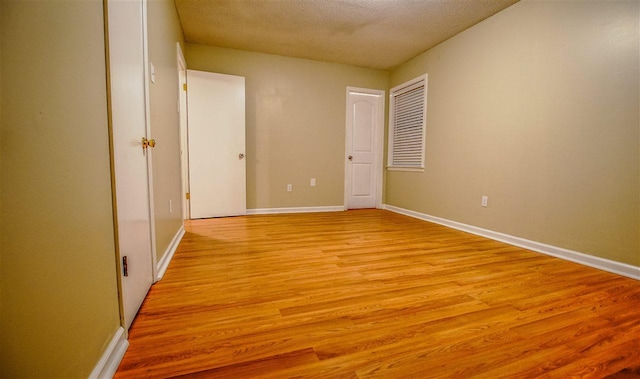 empty room featuring a textured ceiling and light wood-type flooring