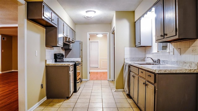 kitchen featuring tasteful backsplash, electric range, and light wood-type flooring