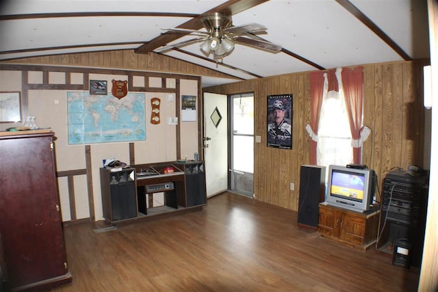 living room with ceiling fan, vaulted ceiling with beams, wood walls, and dark hardwood / wood-style floors