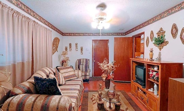 living room with a textured ceiling, wood-type flooring, and ceiling fan