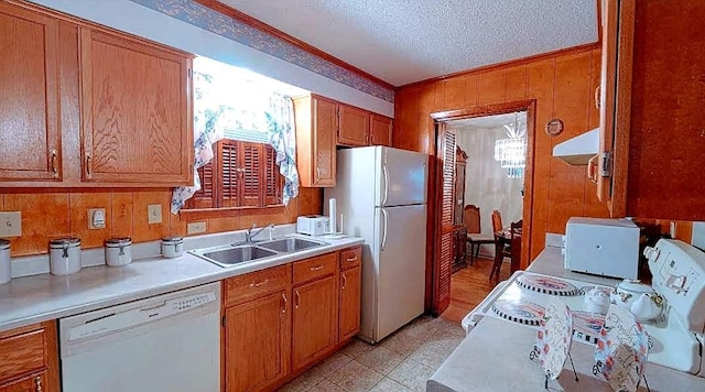 kitchen featuring white appliances, light tile floors, a textured ceiling, sink, and ornamental molding