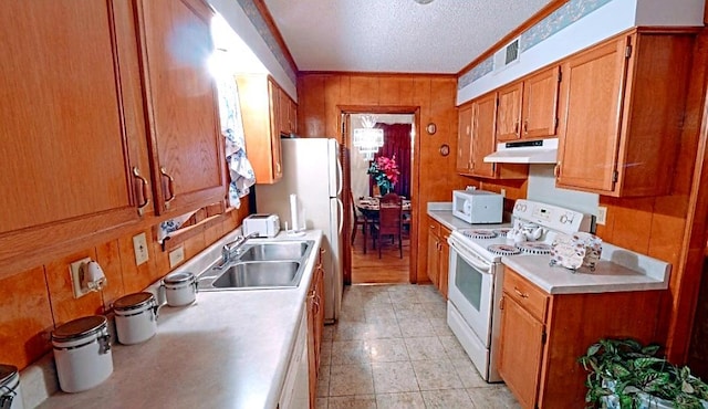 kitchen with light tile floors, a textured ceiling, white appliances, crown molding, and sink