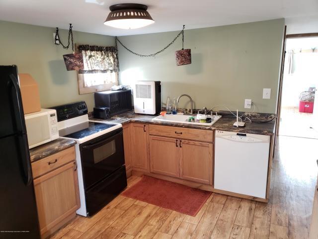 kitchen with white appliances, sink, and light hardwood / wood-style flooring