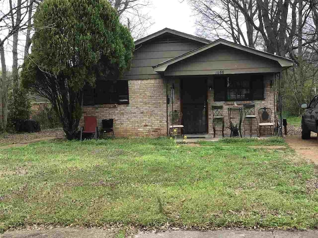 view of front of home with covered porch and a front lawn