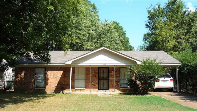 single story home with a front yard, covered porch, and a carport