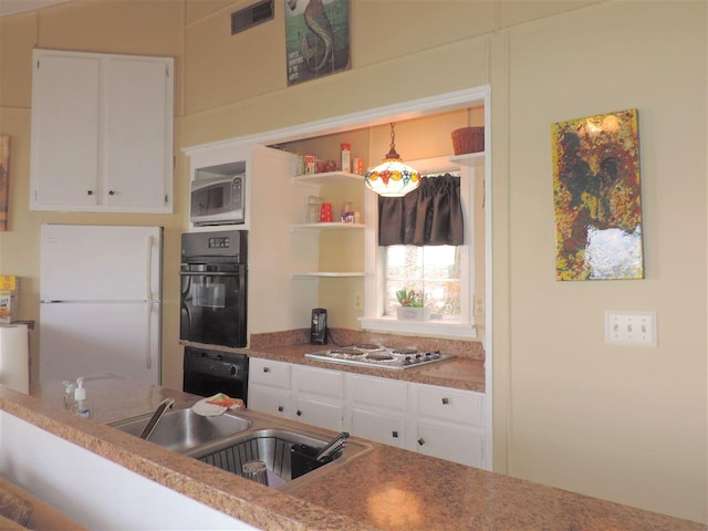 kitchen with pendant lighting, white appliances, white cabinetry, and sink