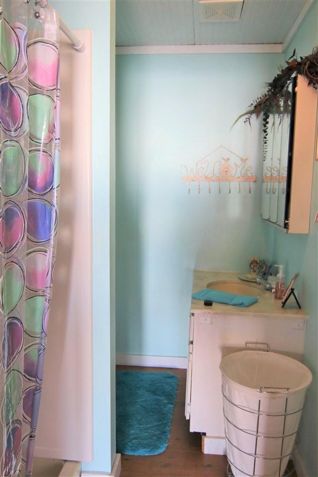 bathroom featuring crown molding and hardwood / wood-style floors