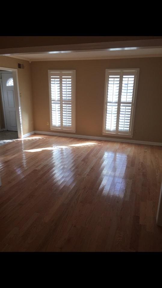 spare room with dark wood-type flooring and a healthy amount of sunlight