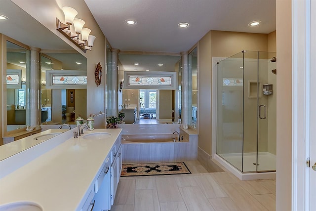 bathroom featuring oversized vanity, separate shower and tub, and ornate columns